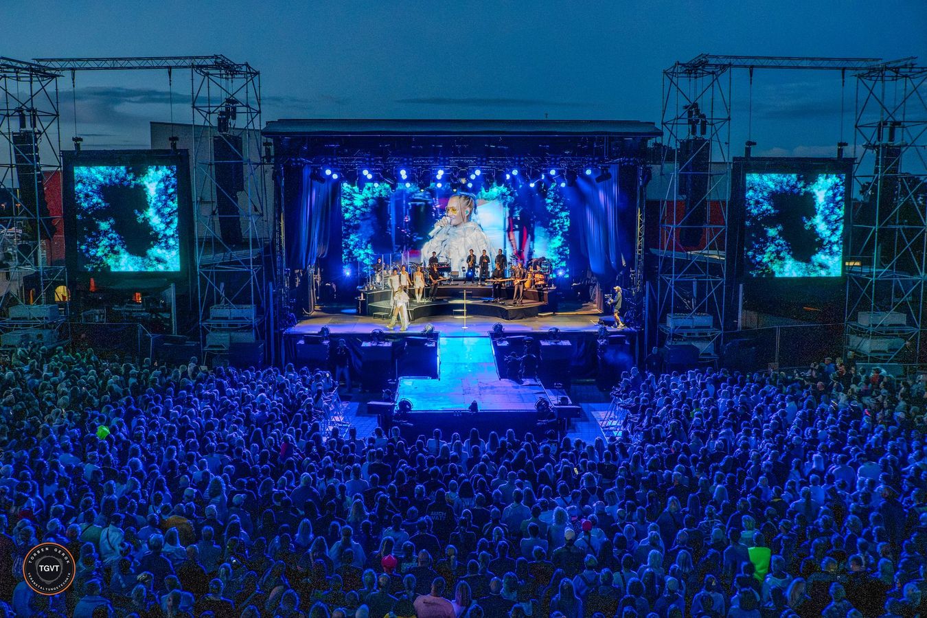 Open-Air-Konzert in der Dämmerung mit LED-Wänden und vollem Publikum